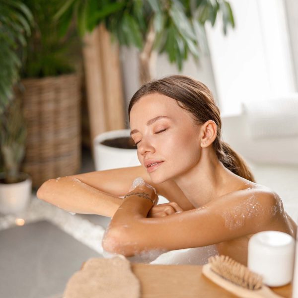 relaxed-young-woman-leaning-on-bathtub-side-while-Y58RNL4.jpg